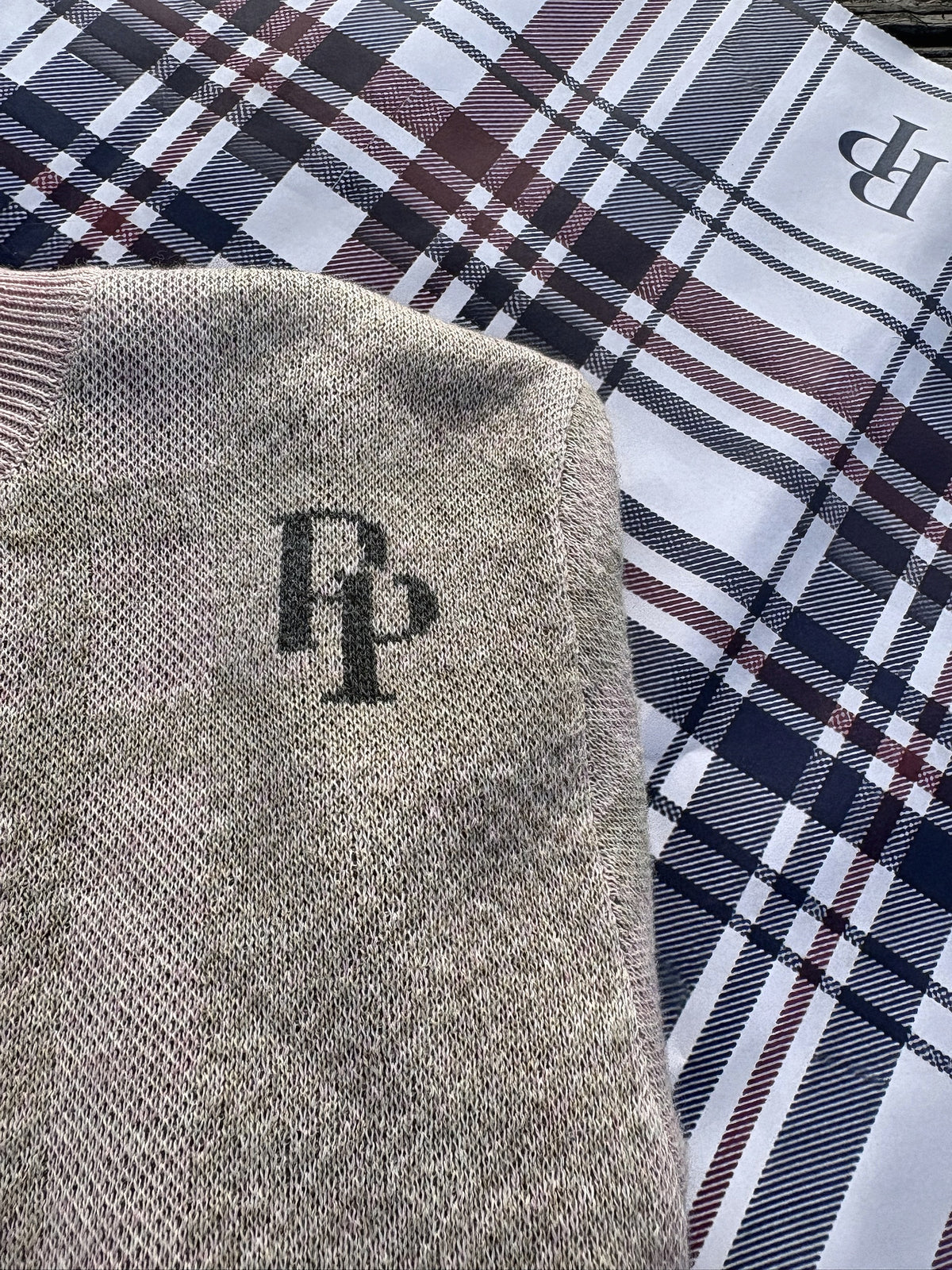 Close-up of the PP monogram on the French Slate & Rose crewneck sweater