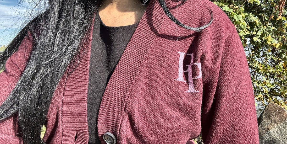 Burgundy & Rose Pink monogram cardigan worn over a black top, outdoors