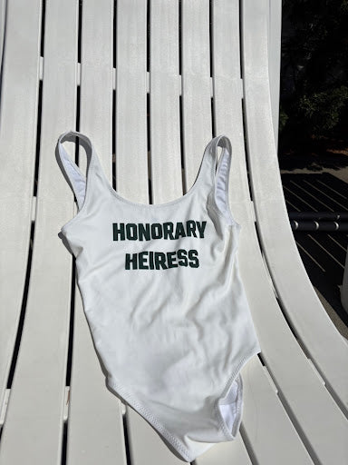 Honorary Heiress™ Varsity Swimsuit - flat lay on white lounge chair