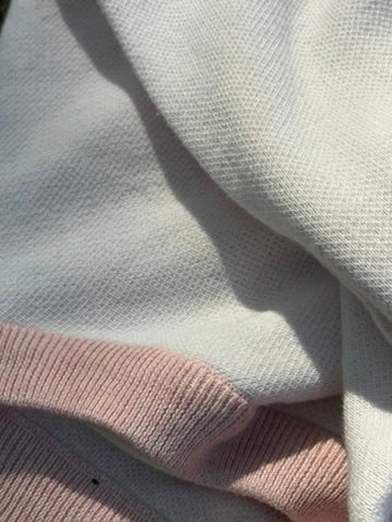 Close-up of the cream knit and lychee pink ribbed trim of the Selective sweater
