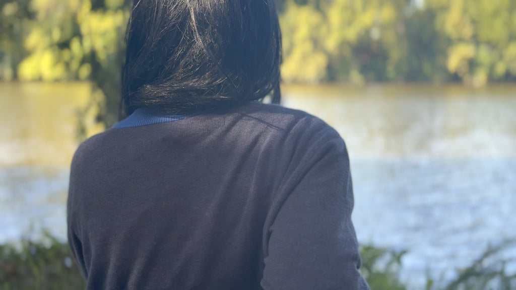 Back view of the Public Prep Preppy Cardigan in Navy & Collegiate Blue by the water