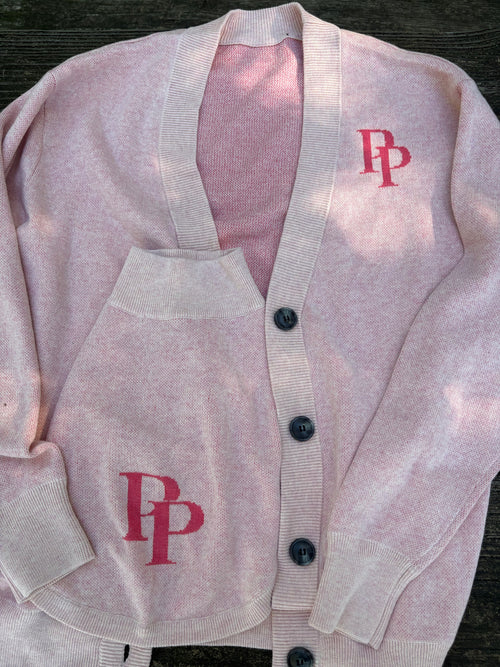 Close-up of the pink PP monogram on the cardigan and matching dog sweater