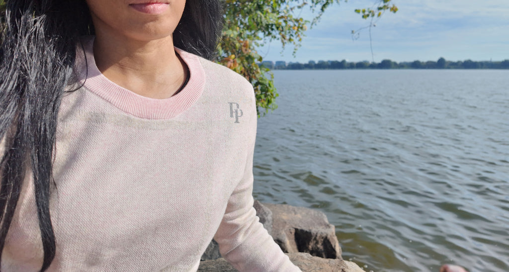 French Slate & Rose crewneck sweater with the slate PP monogram at the shoulder, by the water