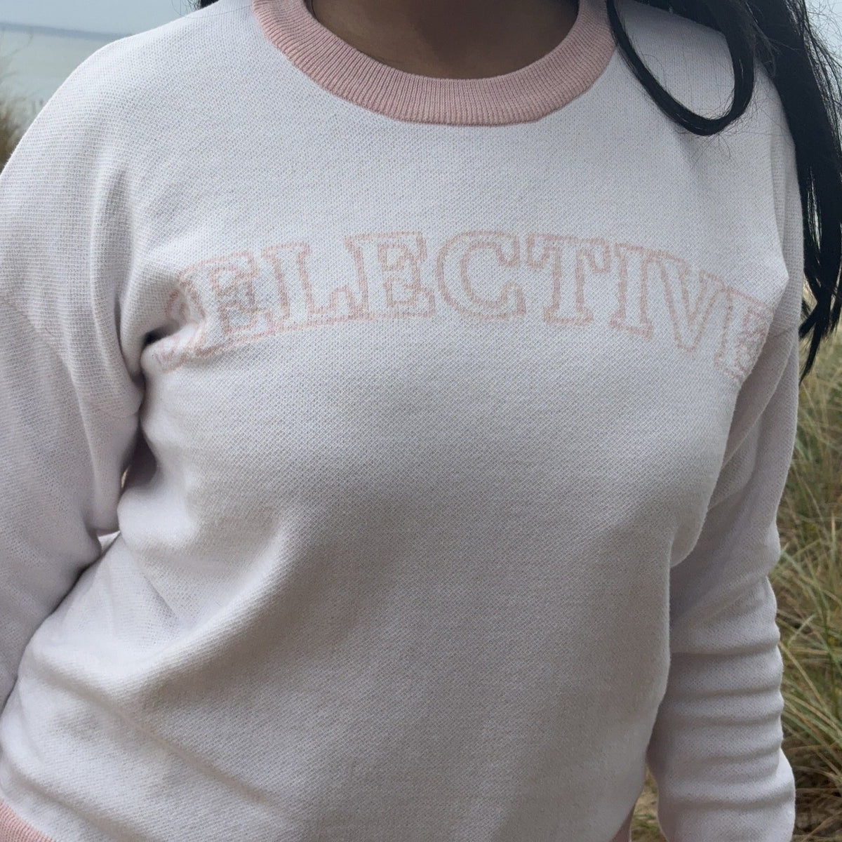 Selective sweater close-up with pink lettering and trim