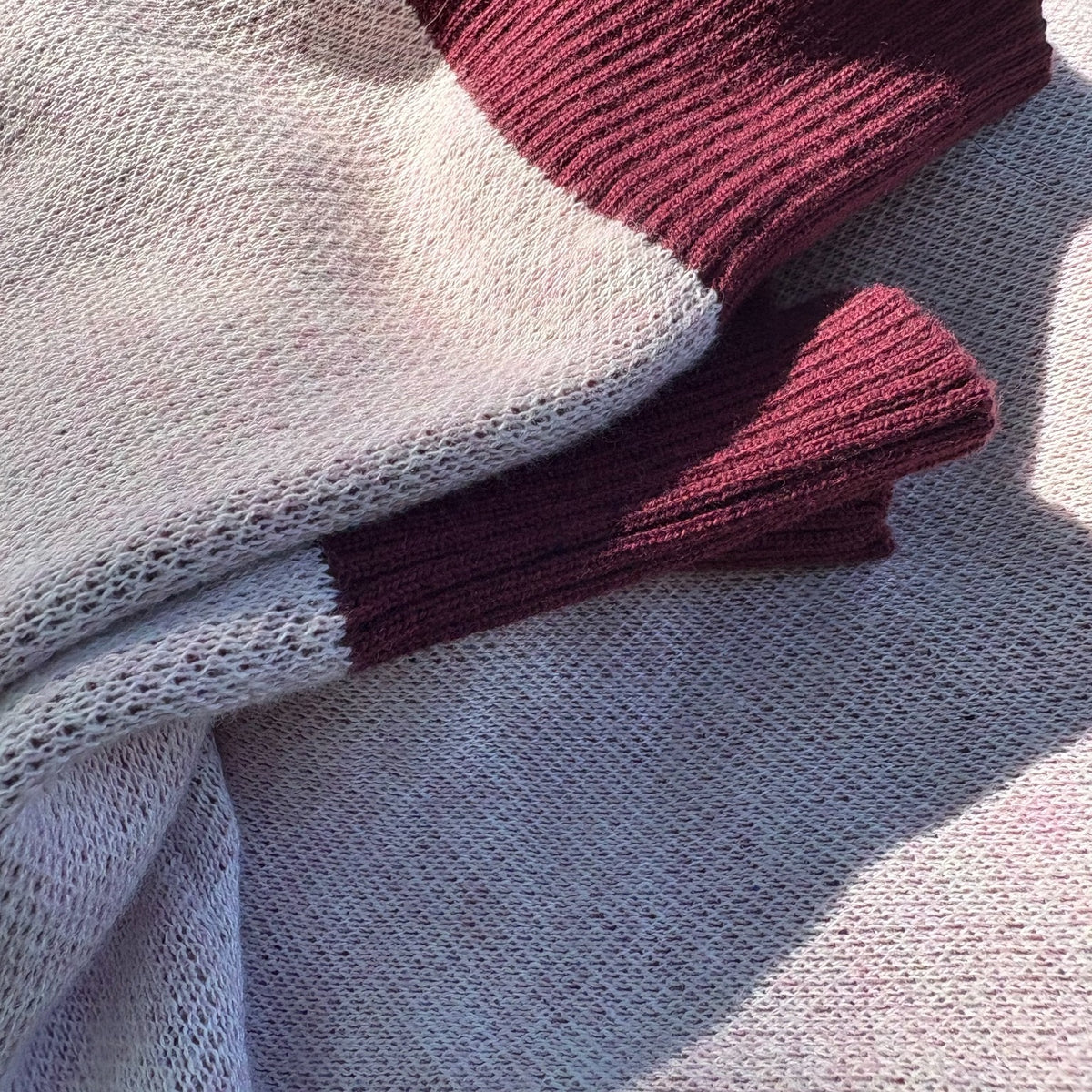 Detail of Public Prep Strawberry & Plum sweater vest showing plum ribbed trim against strawberry knit