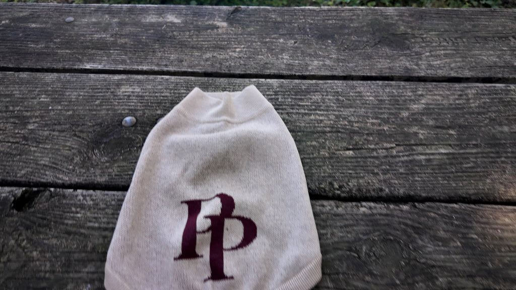 Chai & Crimson dog sweater with the crimson PP monogram on a wooden table