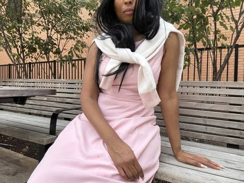 Anissa wearing the Selective Sweater draped over a pink dress