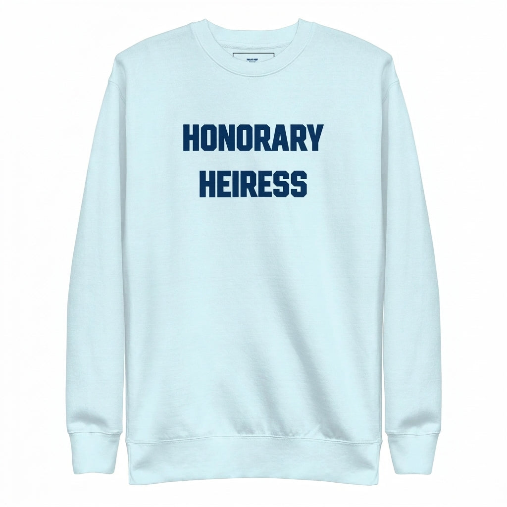 Flat lay composition of the sky blue Honorary Heiress crewneck sweatshirt on marble with accessories
