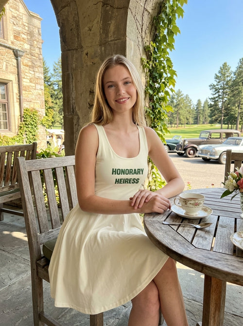 Model wearing the cream HONORARY HEIRESS tennis dress at an outdoor patio